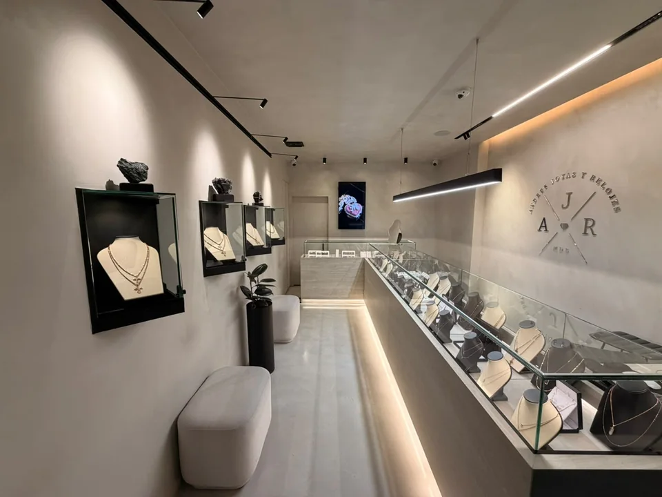 Interior de la tienda: vitrinas iluminadas y el logo en la pared